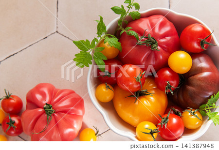 Fresh organic heirloom tomatoes in white bowl Fresh organic heirloom tomatoes in white bowl 141387948