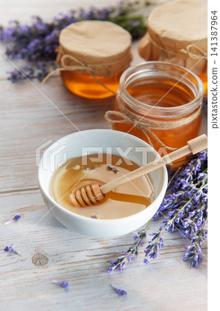 Honey jars and lavender flowers on wooden table Honey jars and lavender flowers on wooden table 141387964