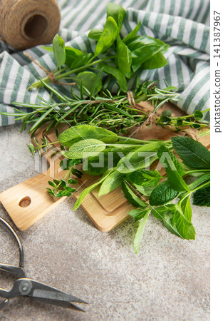 Fresh herbs with garden scissors and twine on board Fresh herbs with garden scissors and twine on board 141387967