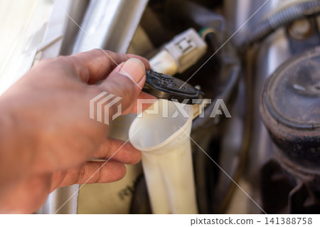 Checking brake fluid cap and washer reservoir handle during vehicle inspection for safe operation. Checking brake fluid cap and washer reservoir handle during vehicle inspection for safe operation. 141388758