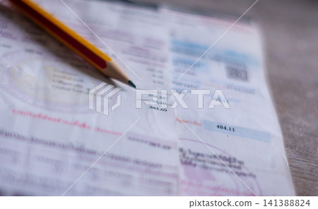 Electricity bill with expense records showing household costs income planning and financial balance. Electricity bill with expense records showing household costs income planning and financial balance. 141388824