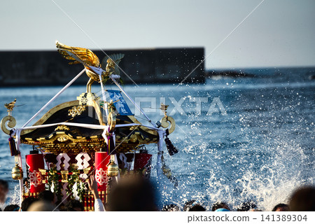 The spray of seawater rises as if to welcome the portable shrine as it makes its way out to sea during the Hamakoshi Festival. 141389304