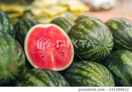 Several large sweet green watermelons and cut watermelons, young green watermelons. Several large sweet green watermelons and cut watermelons, young green watermelons. 141389622