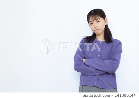 A woman thinking with her arms folded A woman thinking with her arms folded 141390144