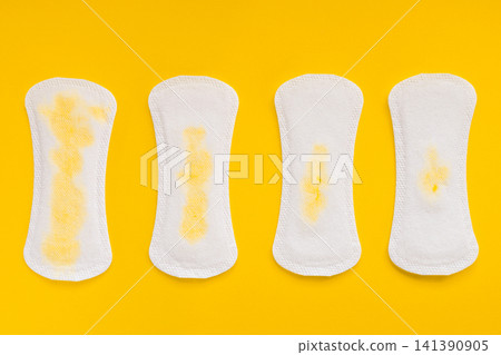 Four Sanitary Pads Showing Different Levels of Urinary Leakage on Yellow Background Four Sanitary Pads Showing Different Levels of Urinary Leakage on Yellow Background 141390905