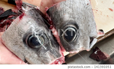 A close-up of a fresh tuna head and its large eyeballs. A close-up of a fresh tuna head and its large eyeballs. 141391051