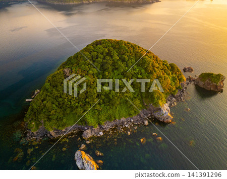 A drone aerial view of the sunset over Karasubejima Island in Sekumi, Wakasa Town, Fukui Prefecture, and Wakasa Bay. A drone aerial view of the sunset over Karasubejima Island in Sekumi, Wakasa Town, Fukui Prefecture, and Wakasa Bay. 141391296