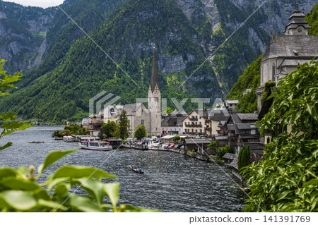 Hallstatt village with its church on the lake in Salzkammergut, Upper Austria, suitable as a calm wallpaper or background. 141391769