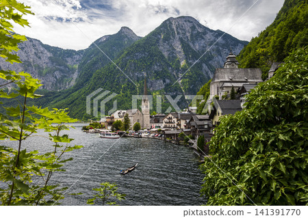 Hallstatt village and scenic lakeside in the Austrian Alps, illustrating European small town charm with classic summer atmosphere. Hallstatt village and scenic lakeside in the Austrian Alps, illustrating European small town charm with classic summer atmosphere. 141391770