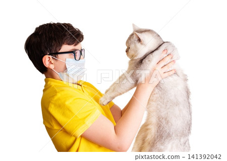 A boy in glasses and medical mask holds his white cat A boy in glasses and medical mask holds his white cat 141392042