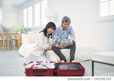 A smiling senior couple preparing for a trip. A smiling senior couple preparing for a trip. 141392105