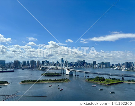 A view of the Rainbow Bridge and the Tokyo skyline from Odaiba, with the blue sky stretching across Tokyo Bay. A view of the Rainbow Bridge and the Tokyo skyline from Odaiba, with the blue sky stretching across Tokyo Bay. 141392260
