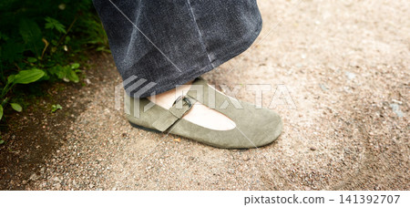 Shoe on a gravel path near plants during the day Shoe on a gravel path near plants during the day 141392707