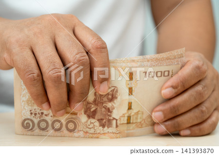 Asian woman holding Thai banknotes money, economy finance exchange trade investment. Asian woman holding Thai banknotes money, economy finance exchange trade investment. 141393870