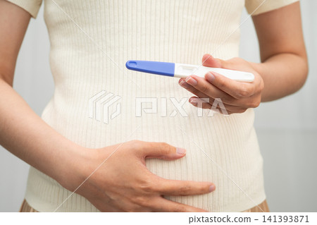 Asian holding pregnancy test for female of ovulation day, fetus, maternity, childbirth, birth control. Asian holding pregnancy test for female of ovulation day, fetus, maternity, childbirth, birth control. 141393871