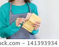 A woman taking money out of her wallet - an image of household budget management. 141393934