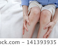 Image of a woman's tired legs as she presses on her calves. 141393935