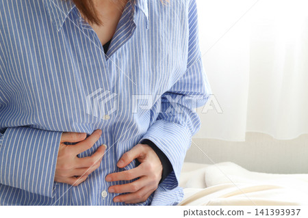 畫面中一名女子摀著肚子,似乎正在經歷腹痛或感到不適。 畫面中一名女子摀著肚子,似乎正在經歷腹痛或感到不適。 141393937