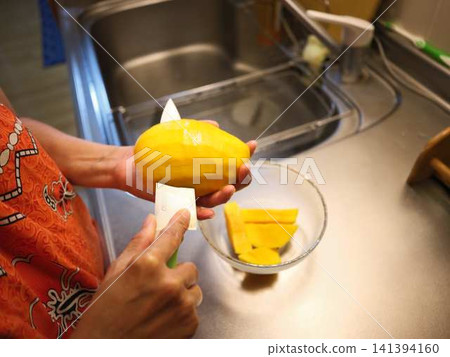 The hands of a woman cutting a mango 141394160