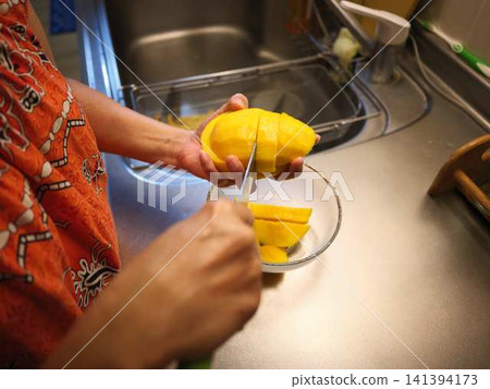 The hands of a woman cutting a mango The hands of a woman cutting a mango 141394173