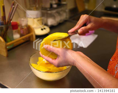 The hands of a woman cutting a mango 141394181