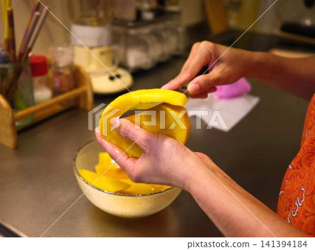 The hands of a woman cutting a mango The hands of a woman cutting a mango 141394184