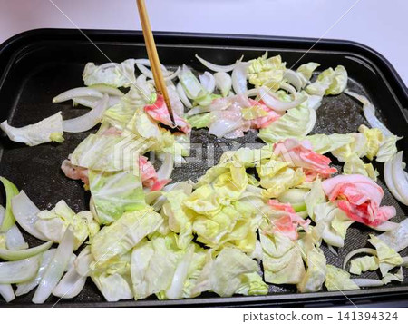 在煎鍋中煮熟的炒豬肉蔬菜 在煎鍋中煮熟的炒豬肉蔬菜 141394324