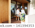 A family relaxing on a wooden deck terrace. 141394353