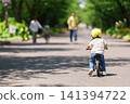 A 2-year-old boy riding a balance bike 141394722