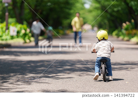 A 2-year-old boy riding a balance bike 141394722