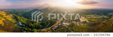 Aerial view of the lush Tegalalang landscape featuring a winding river flowing through dense tropical forest and terraced fields in Indonesia 141394766