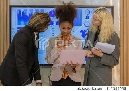 Diverse colleagues gather in brainstorm discuss statistics together. Diverse colleagues gather in brainstorm discuss statistics together. 141394966
