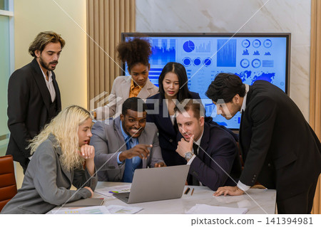 Diverse colleagues gather in brainstorm discuss statistics together. Diverse colleagues gather in brainstorm discuss statistics together. 141394981