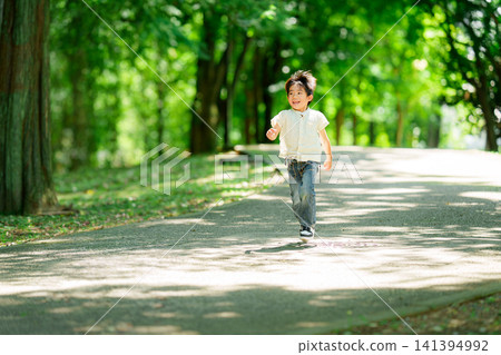 A boy who runs in a fresh green park A boy who runs in a fresh green park 141394992
