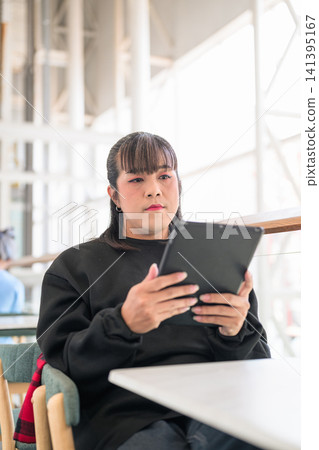 Thai Transgender Woman Looking at Digital Tablet Screen Thai Transgender Woman Looking at Digital Tablet Screen 141395167