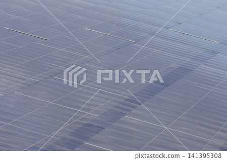 A close-up shot from the air of a neatly arranged array of solar panels. A close-up shot from the air of a neatly arranged array of solar panels. 141395308
