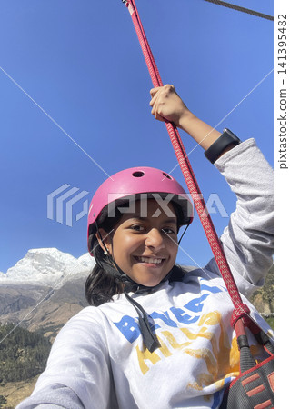 Happy girl ziplining in mountain valley landscape. UGC Happy girl ziplining in mountain valley landscape. UGC 141395482