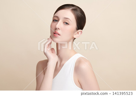 A beautiful young Asian woman with clean, fresh skin against a beige background. Skincare, facial treatment, cosmetology, beauty, and spa. An elegant portrait of an Asian woman. A beautiful young Asian woman with clean, fresh skin against a beige background. Skincare, facial treatment, cosmetology, beauty, and spa. An elegant portrait of an Asian woman. 141395523