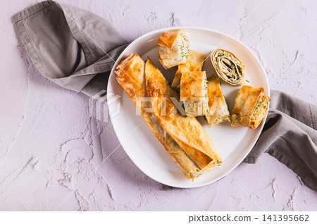 Close up of delicious grilled rolls with cottage cheese, cheese and herbs on a plate on the table top view 141395662