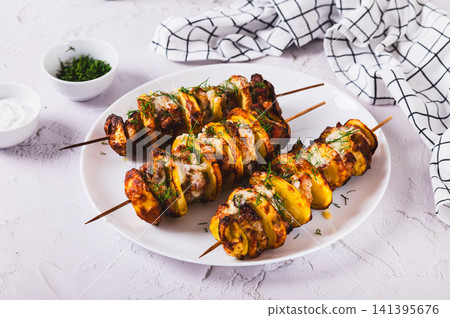 Sulvaki made from meat and potatoes on skewers on a plate on the table Sulvaki made from meat and potatoes on skewers on a plate on the table 141395676