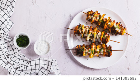 Sulvaki made from meat and potatoes on skewers on a plate on the table top view web banner Sulvaki made from meat and potatoes on skewers on a plate on the table top view web banner 141395682