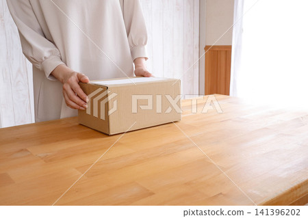 A woman with a cardboard box full of belongings A woman with a cardboard box full of belongings 141396202
