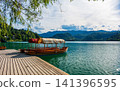 Traditional wooden pletna boats moored in a small bay on Lake Bled, Slovenia, ready to take visitors to the iconic church on Bled Island. 141396595