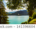 Scenic view of Lake Bled in Slovenia with turquoise water, the iconic Church of the Assumption on Bled Island, surrounded by forests and the majestic Julian Alps. 141396604