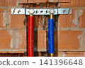 Modern plumbing system installed inside unfinished brick house wall 141396648
