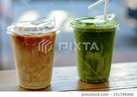 Creamy iced latte and matcha tea near sunny window Creamy iced latte and matcha tea near sunny window 141396866