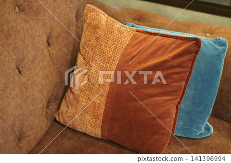 A brown pillow layered over a blue pillow, placed on a brown sofa, object, decor, fashion, copy space 141396994