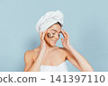 Calm woman applies eye masks 141397110
