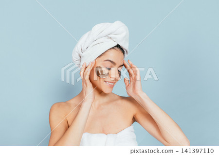 Calm woman applies eye masks Calm woman applies eye masks 141397110