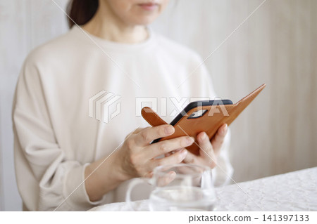 Woman operating a smartphone Woman operating a smartphone 141397133